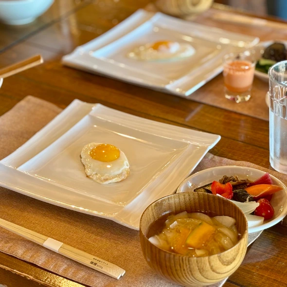 Breakfast: a sunny-side-up egg, miso soup with local onions and pumpkin, and pickles