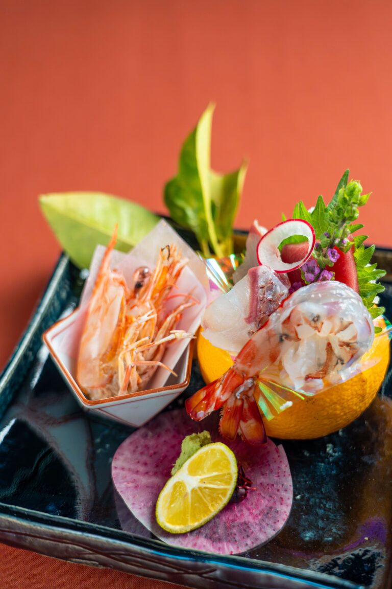 Seasonal Japanese sashimi and shrimp appetizer with fresh seafood, citrus, and edible flowers at Japanese soba restaurant