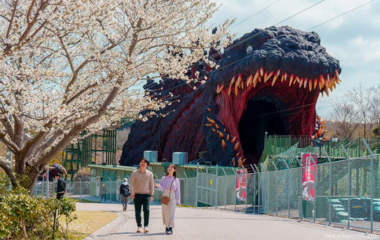 Couple walking near Godzilla zipline with cherry blossoms at Nijigen no Mori Awaji Island