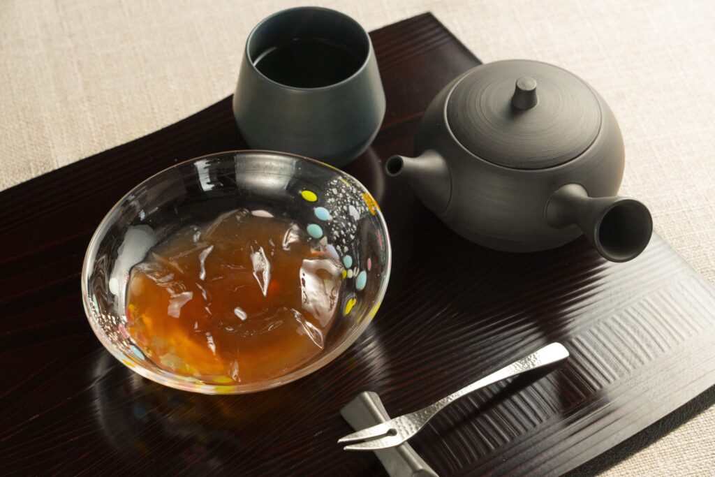 Japanese tea set with traditional wagashi jelly dessert served on a wooden tray