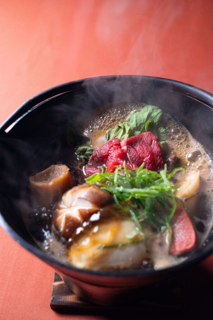Steaming Japanese soup with wagyu beef, mushrooms, and seasonal vegetables