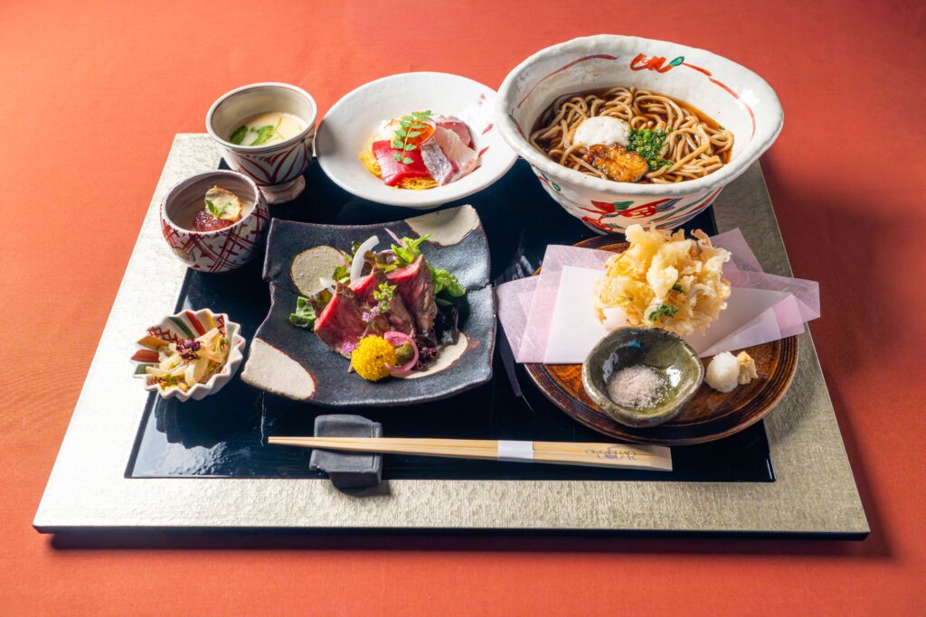 Traditional Japanese set meal with soba noodles, tempura, and seasonal small dishes