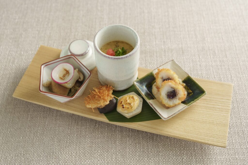 Traditional Japanese appetizer plate with chawanmushi and seasonal garnish