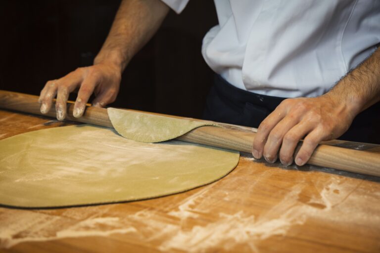 rolling the dough with flour on a big table