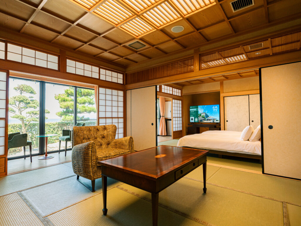 Luxury Japanese ryokan suite on Awaji Island with tatami flooring, ocean view seating area and semi-double beds, private onsen retreat for families