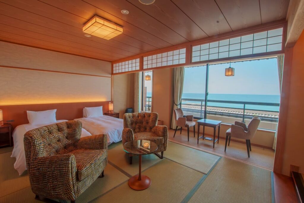 Superior Japanese-style room at Senshin Waho ryokan on Awaji Island with tatami flooring, semi-double bed, seating area, and ocean view of the Seto Inland Sea