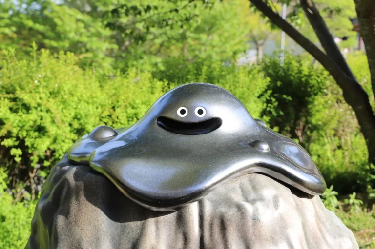 Black slime character on rock at Dragon Quest Island in Nijigen no Mori Awaji Island