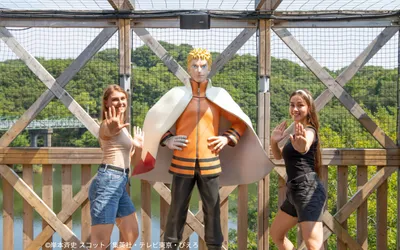 Visitors posing like ninjas with Naruto statue at Nijigen no Mori on Awajishima