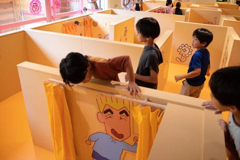 Kids solving puzzles inside Futaba Kindergarten maze at Crayon Shin-chan Adventure Park Nijigen no Mori Awaji Island